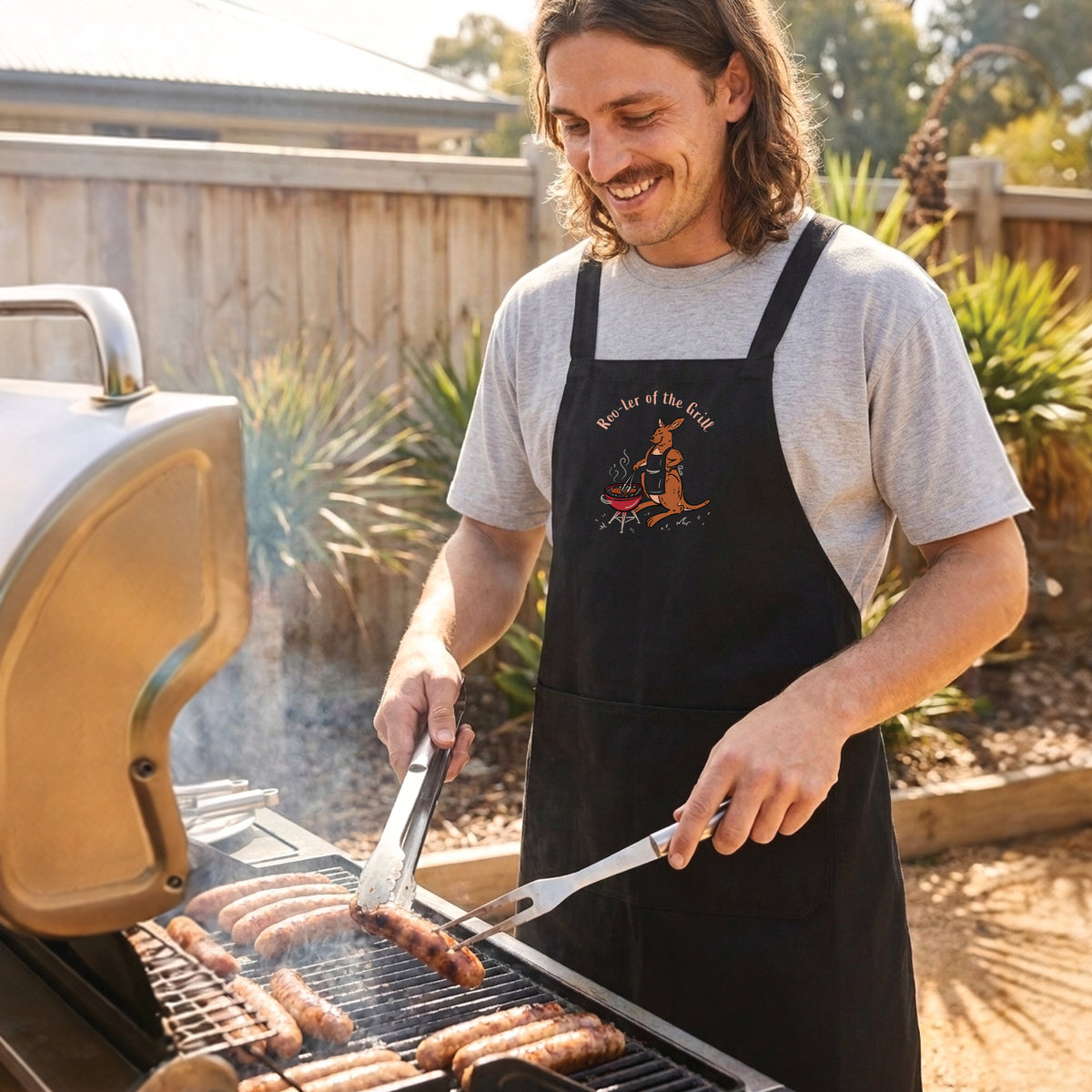 Kangaroo BBQ cotton canvas apron featuring a hand-drawn kangaroo cooking at a barbecue with Roo-ler of the Grill slogan
