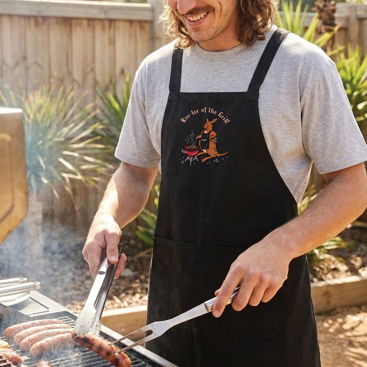 Kangaroo BBQ cotton canvas apron featuring a hand-drawn kangaroo cooking at a barbecue with Roo-ler of the Grill slogan