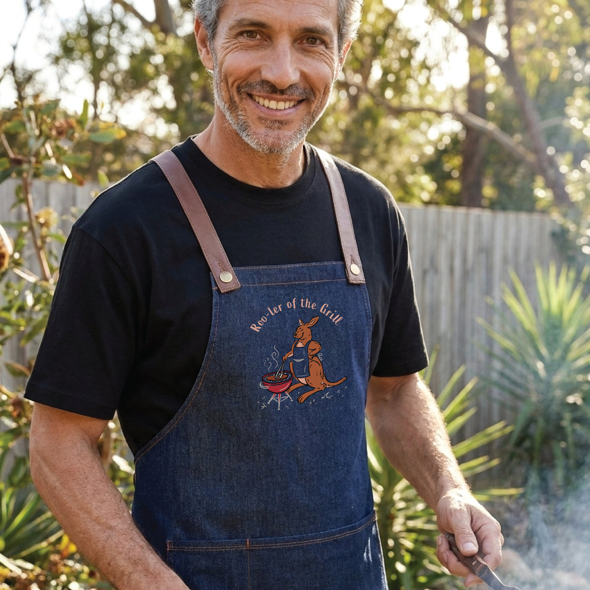 Kangaroo BBQ denim apron featuring a hand-drawn kangaroo cooking at a barbecue with Roo-ler of the Grill slogan