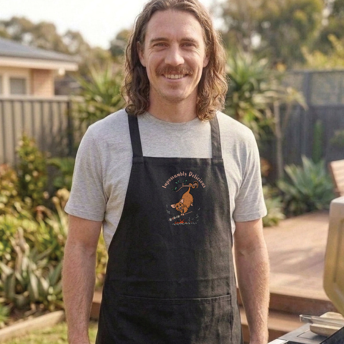 Possum BBQ apron featuring a hand-drawn possum cooking over an open fire with Impossumbly Delicious slogan