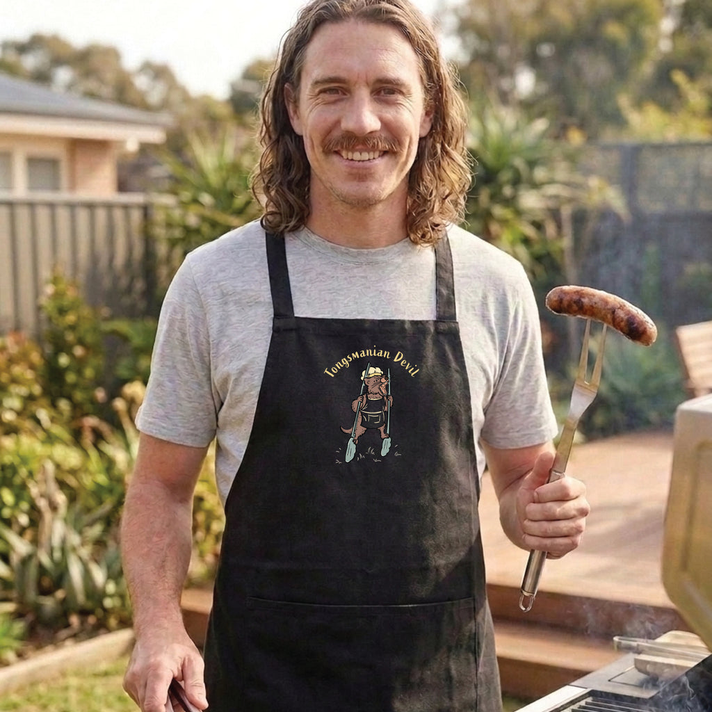 Tasmanian Devil BBQ cotton canvas apron featuring a hand-drawn Tassie devil holding cooking tongs with Tongsmanian Devil slogan