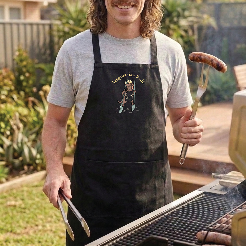 Tasmanian Devil BBQ cotton canvas apron featuring a hand-drawn Tassie devil holding cooking tongs with Tongsmanian Devil slogan