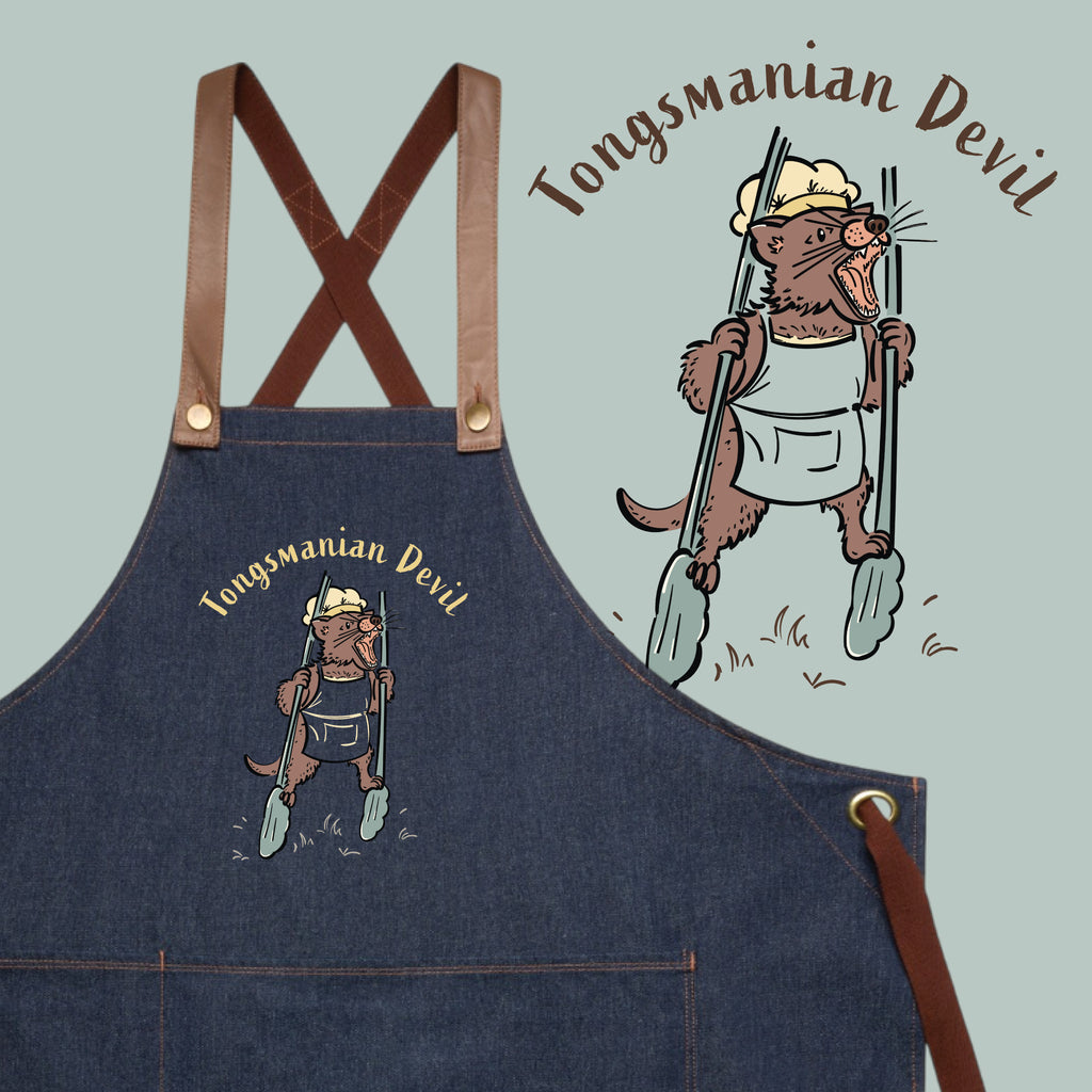 Tasmanian Devil BBQ denim apron featuring a hand-drawn Tassie devil holding cooking tongs with Tongsmanian Devil slogan